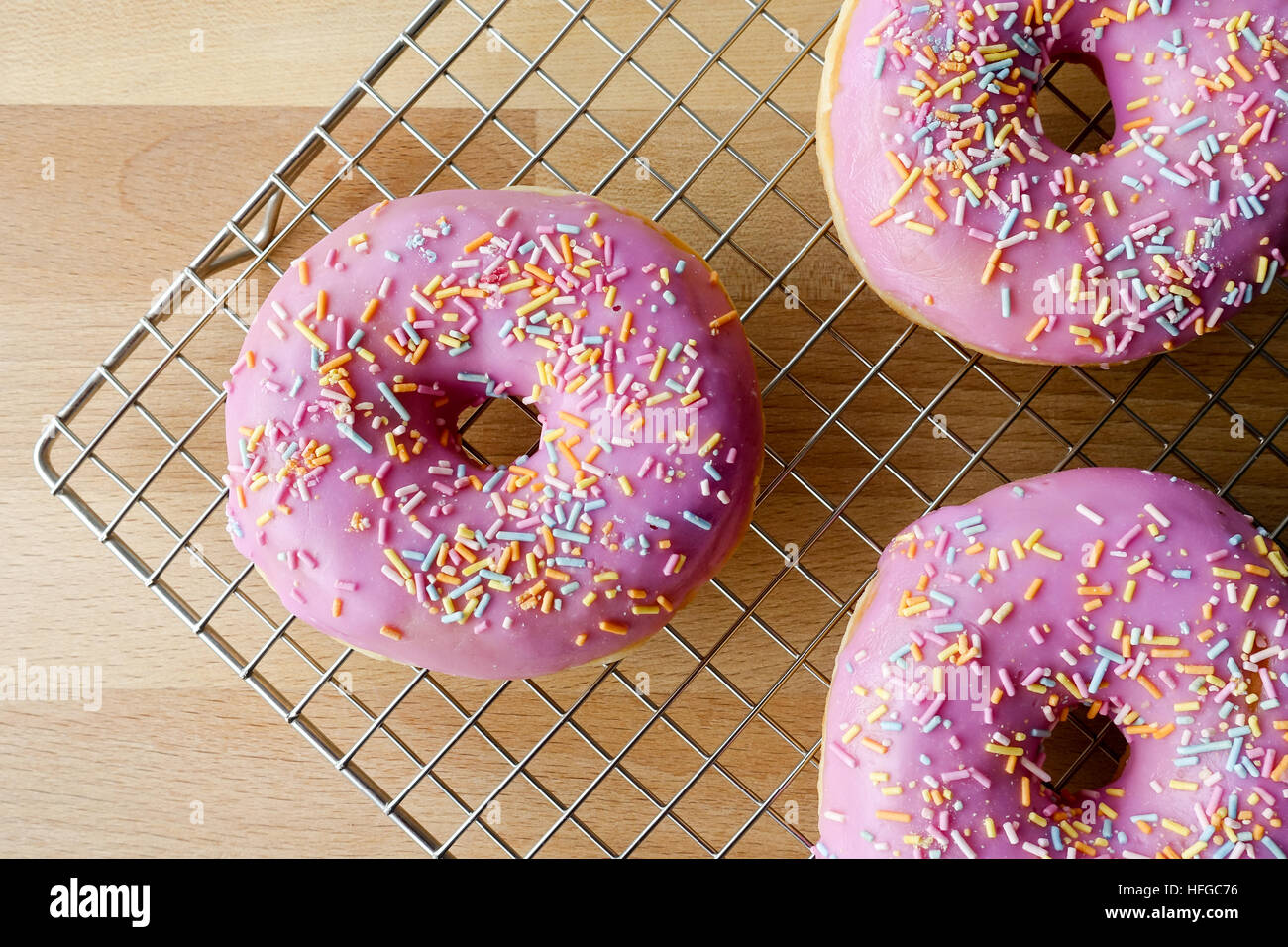 Closeup of Three Pink Doughnuts on Cooling Rack Stock Photo - Alamy