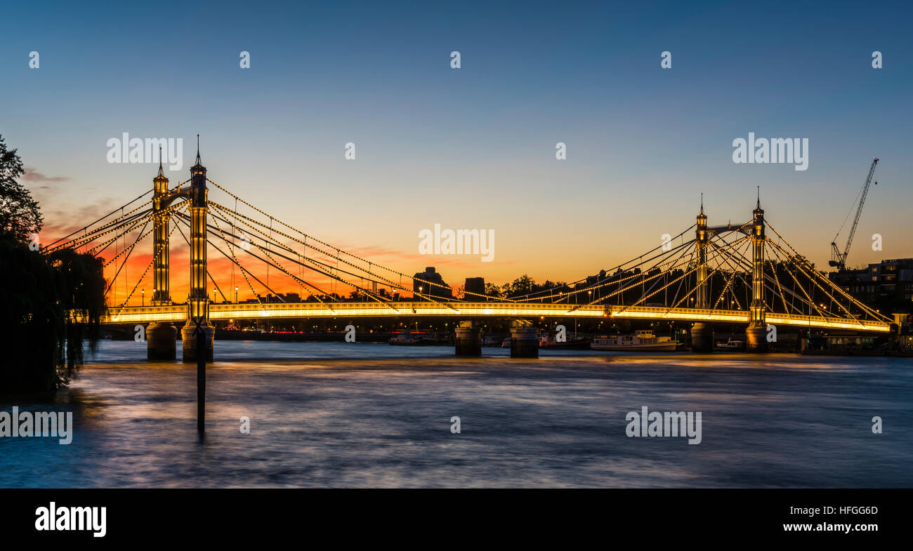 Sunset and red skies behind the Albert Bridge across the River Thames ...