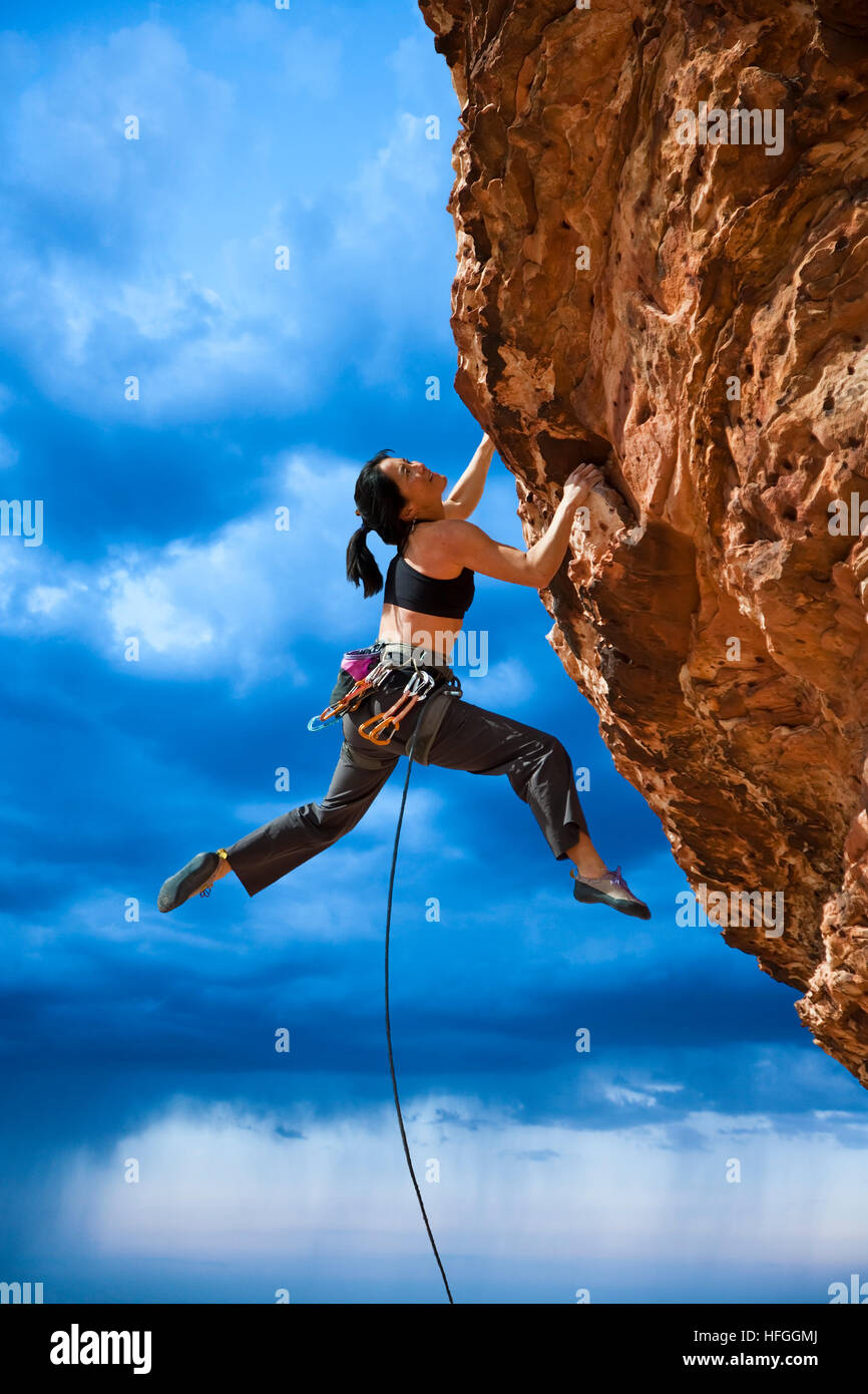 Female climber struggling up a sheer cliff Stock Photo Alamy
