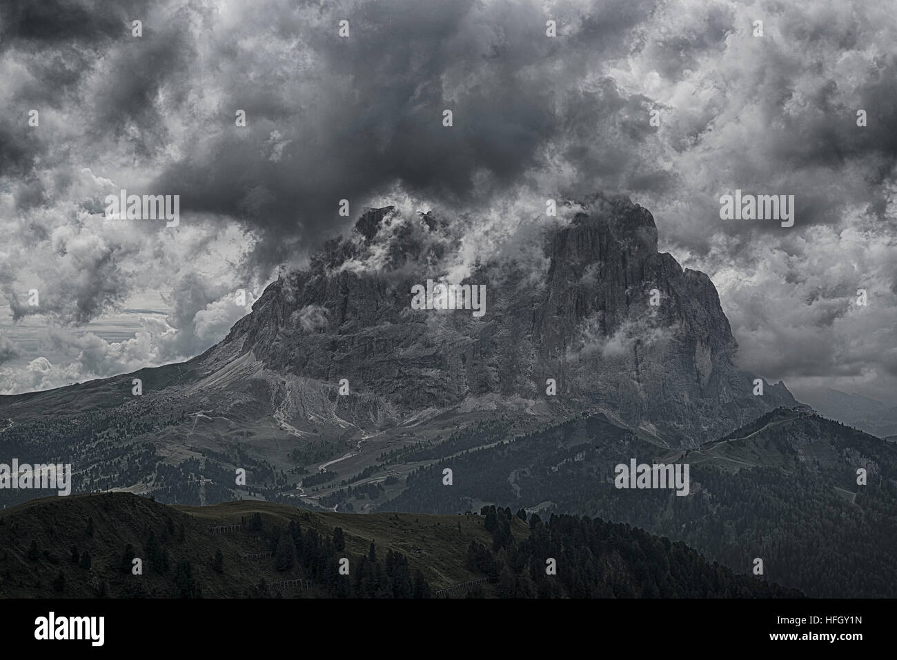 The Top of Langkofel in the clouds seen from Dantercepies, summer afternoon - Val Gardena, Dolomites Stock Photo