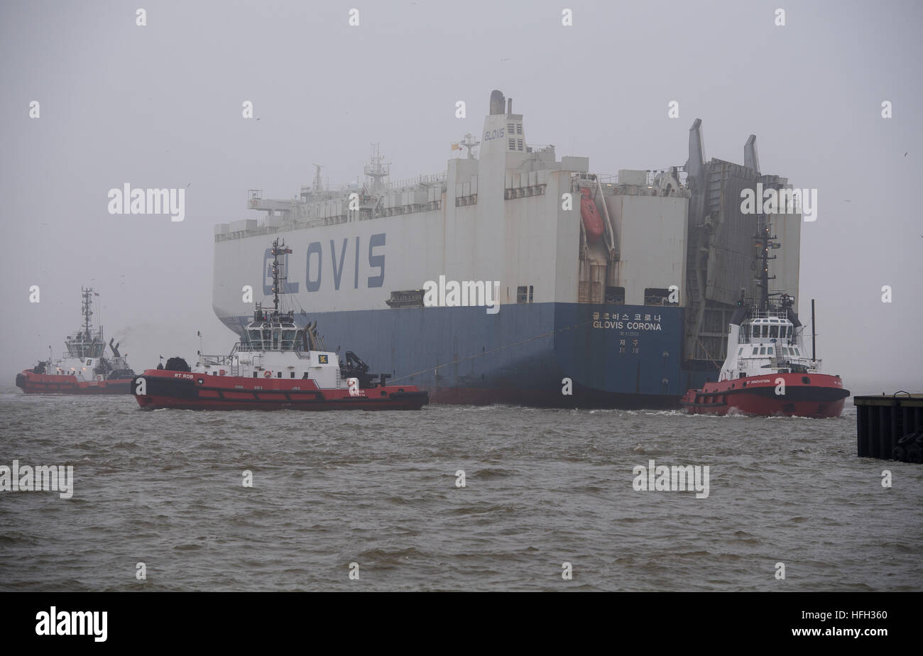 Bremerhaven, Germany. 31st Dec, 2016. The car transport ship 'Glovis Coron, ' wrecked in the storm 'Barbara, ' arrives in thick fog to the Kaiserschleuse lock in Bremerhaven, Germany, 31 December 2016. The Korean freighter, loaded with tanks, among other things, listed after the load shifted and became distressed at sea off the East Frisian island of Wangerooge. By adjusting the ballast water tank, the list could be reduced from 15 to 5 degrees. Experts will secure and re-lash the load in Bremerhaven. Photo: Ingo Wagner/dpa/Alamy Live News Stock Photo
