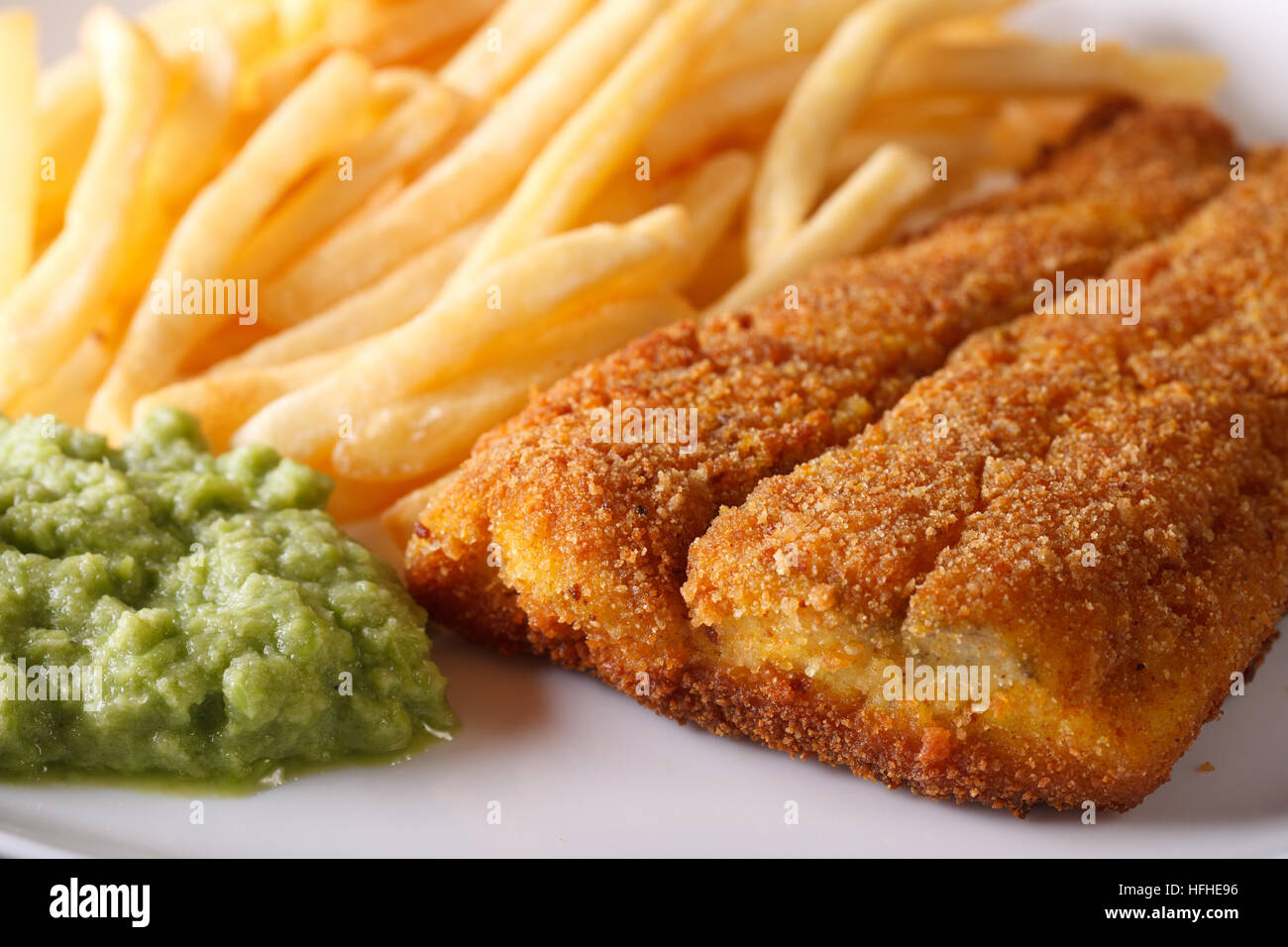 English food: fried fish fillets and chips and pea puree macro. horizontal Stock Photo