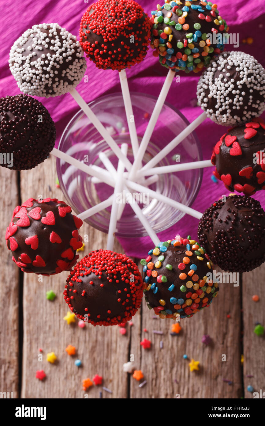 Delicious holiday colored cake pops in a glass closeup. vertical top ...