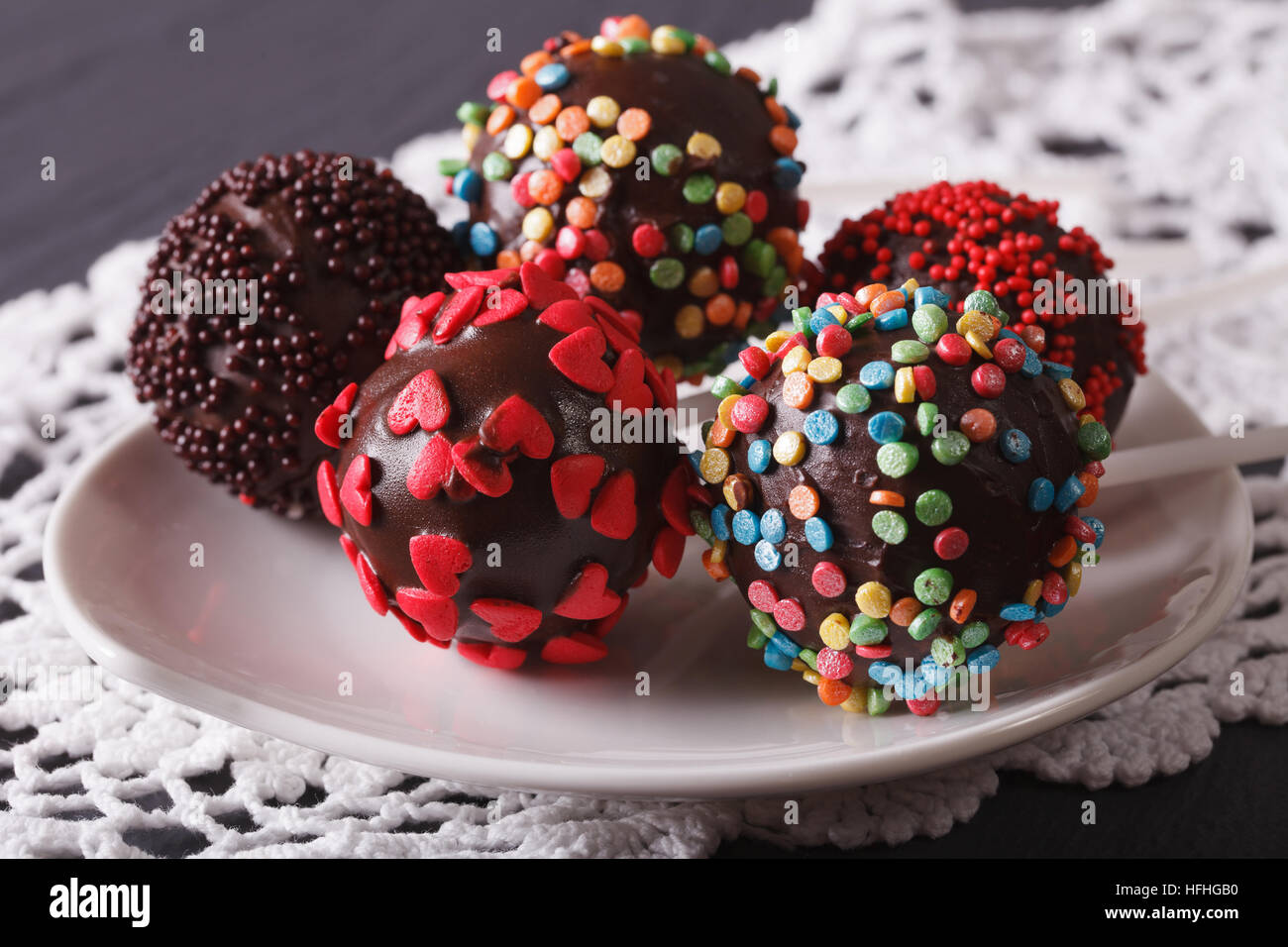 Colourful Pop cakes closeup on a white plate on the table. Horizontal Stock Photo
