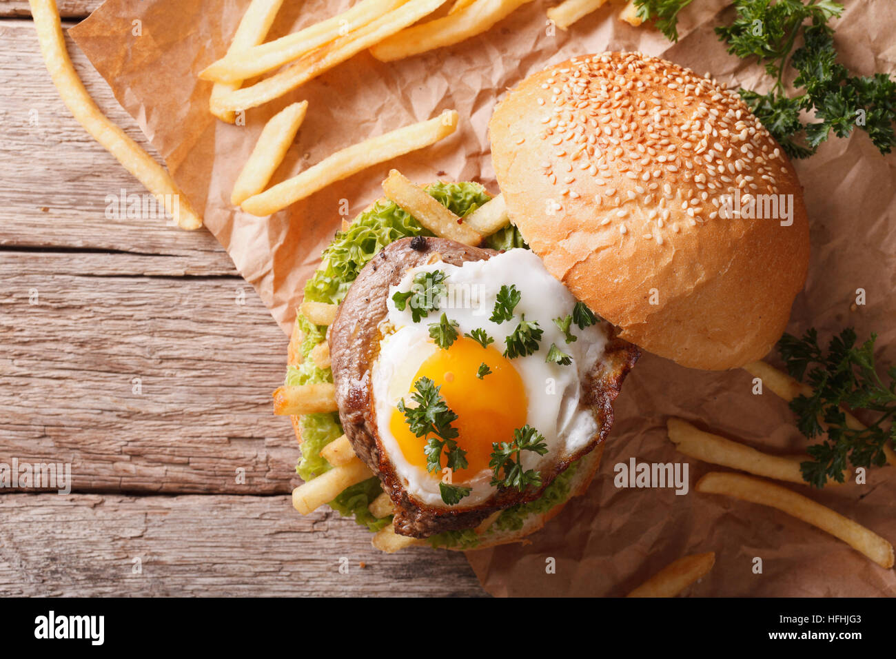 sandwich with grilled meat, a fried egg and French fries. horizontal view from above Stock Photo
