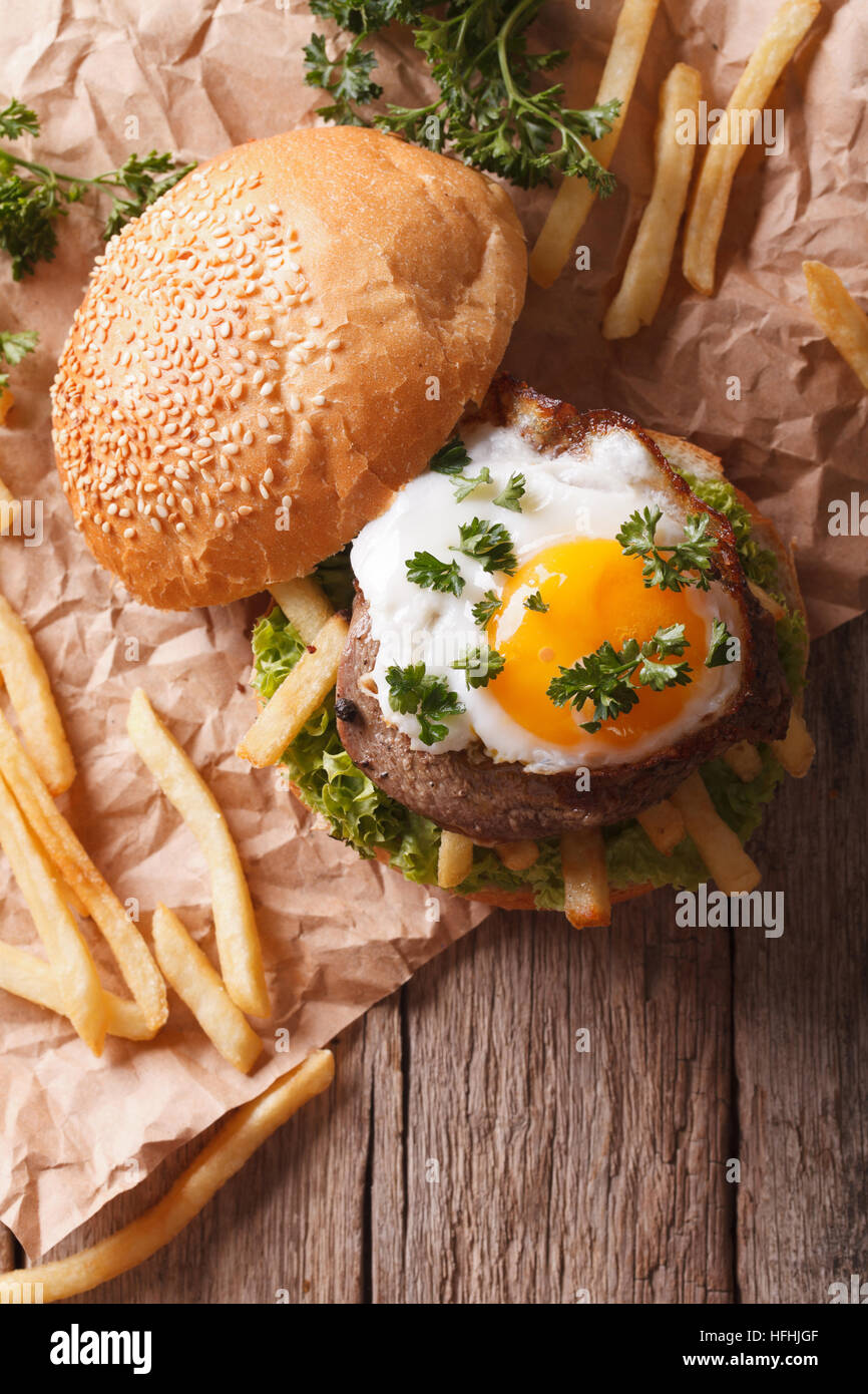 sandwich with grilled meat, a fried egg and French fries. vertical top view Stock Photo