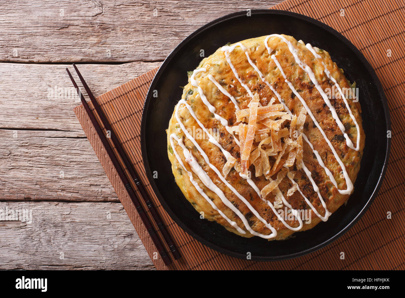 Japanese okonomiyaki on a table and chopsticks. horizontal top view Stock Photo