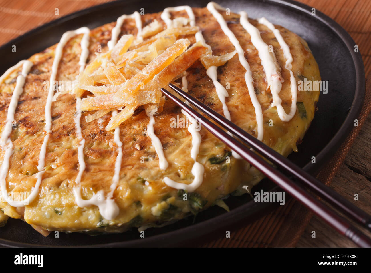 Japanese okonomiyaki pizza on a plate macro. horizontal Stock Photo