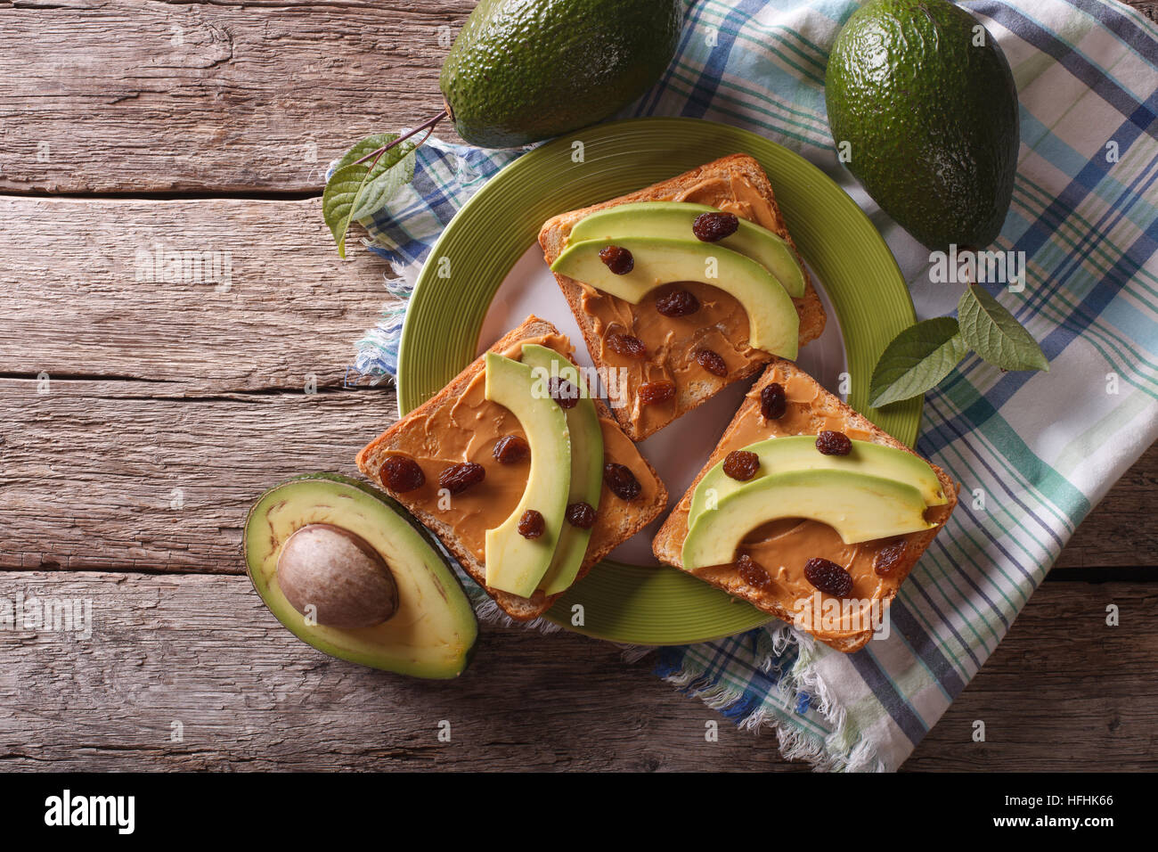 Homemade sandwiches with peanut butter, raisins and avocado on a plate. horizontal top view Stock Photo