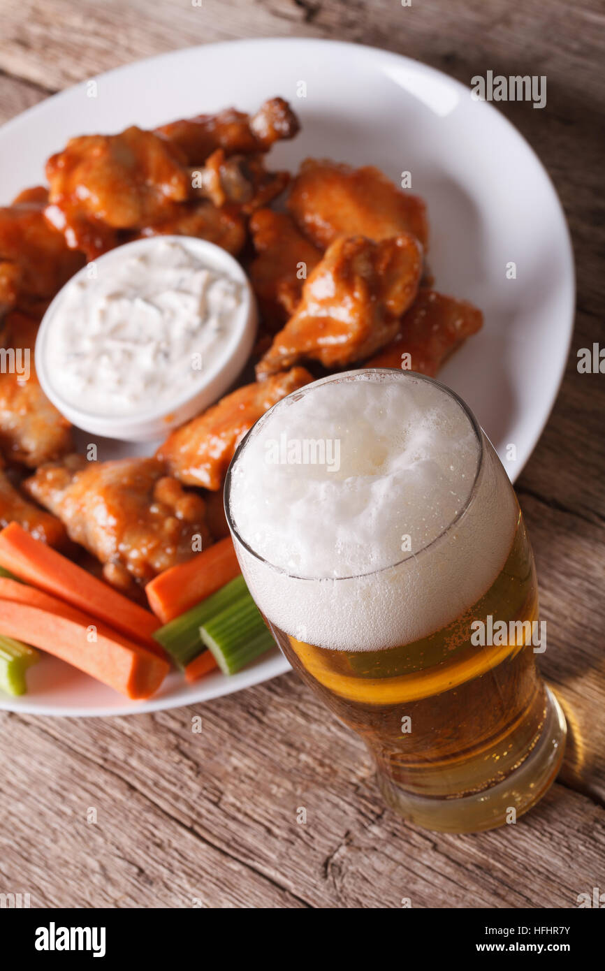 American fast food buffalo wings with sauce and beer on the table closeup vertical Stock Photo