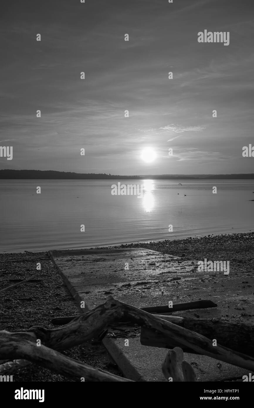 Luminous light envelops everything as the sun sets over the Puget Sound. Black and white image. Stock Photo
