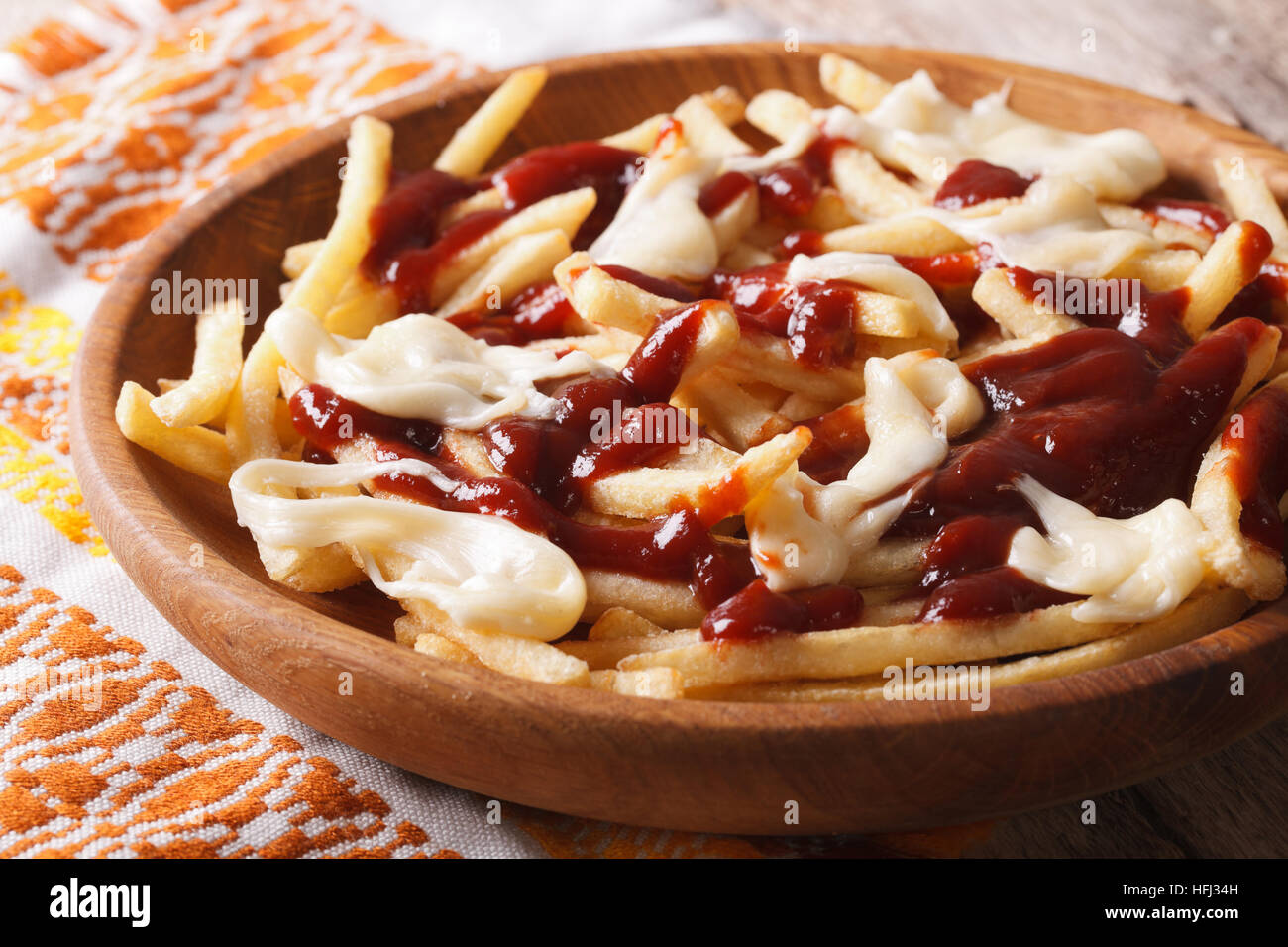 Traditional Canadian fast food poutine with sauce and cheese closeup