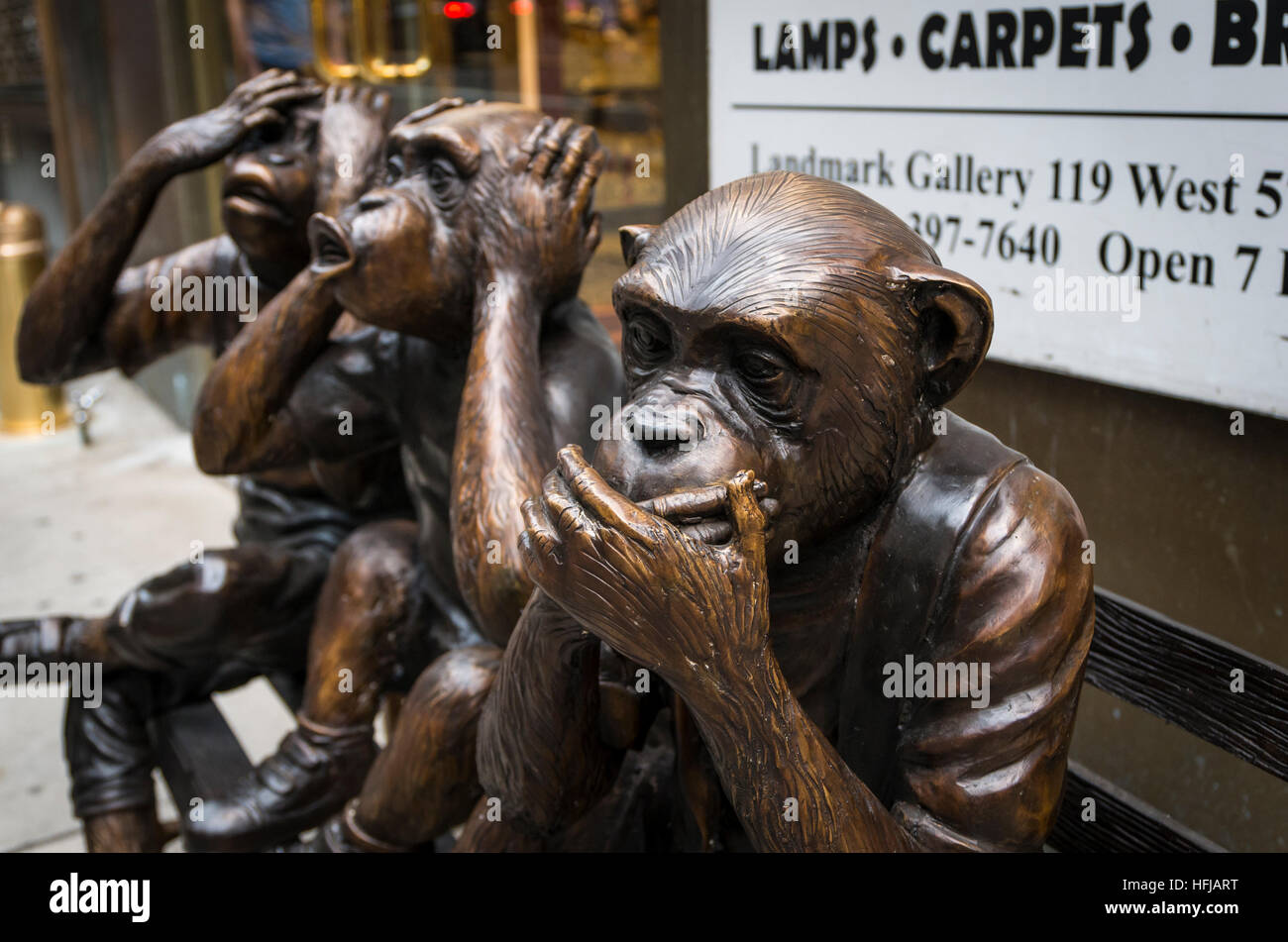Bronze sculpture of three chimpanzees or monkeys on a bench: "See, speak, hear no evil" Stock Photo