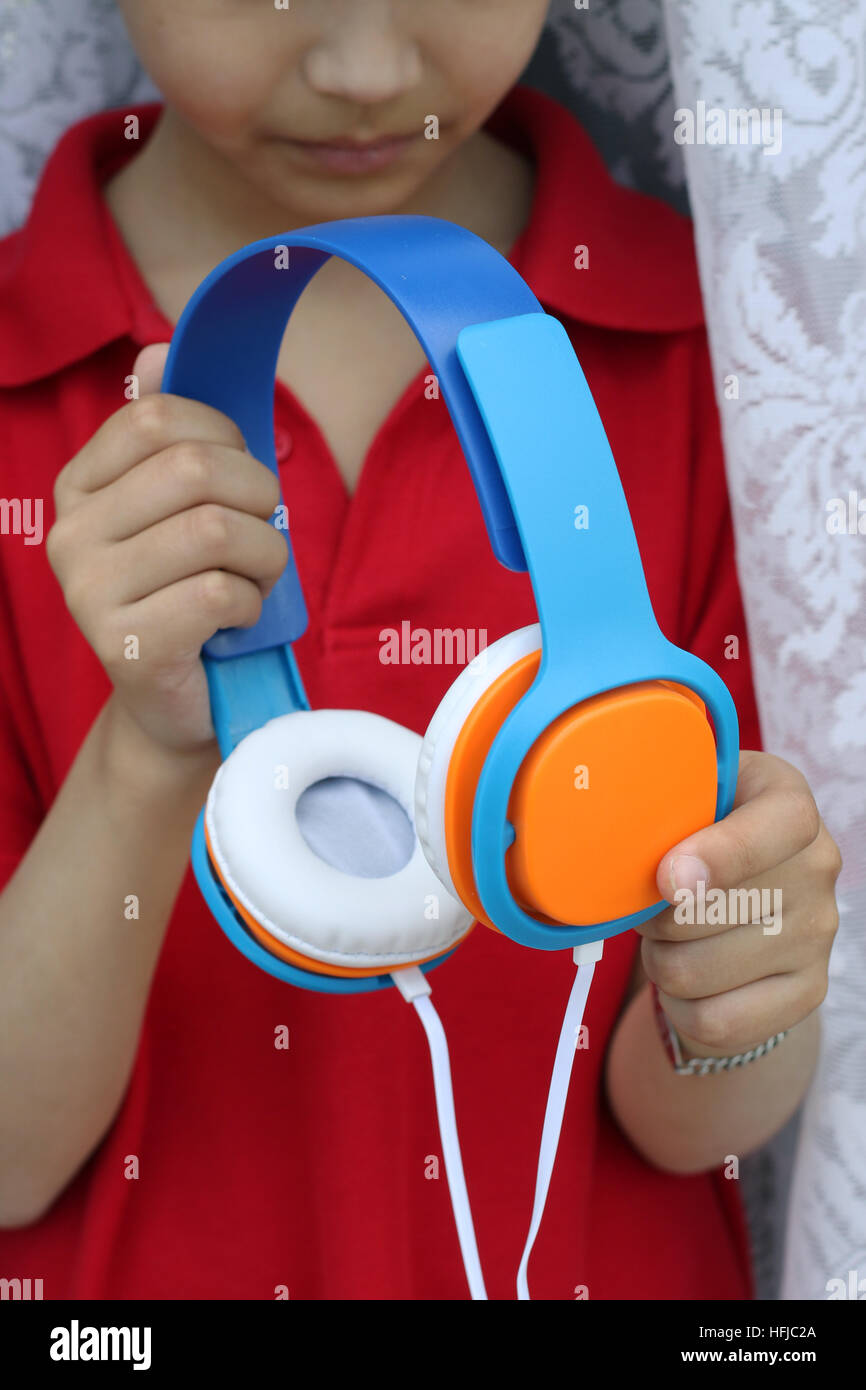 Close up o f Male child holding headphones Stock Photo