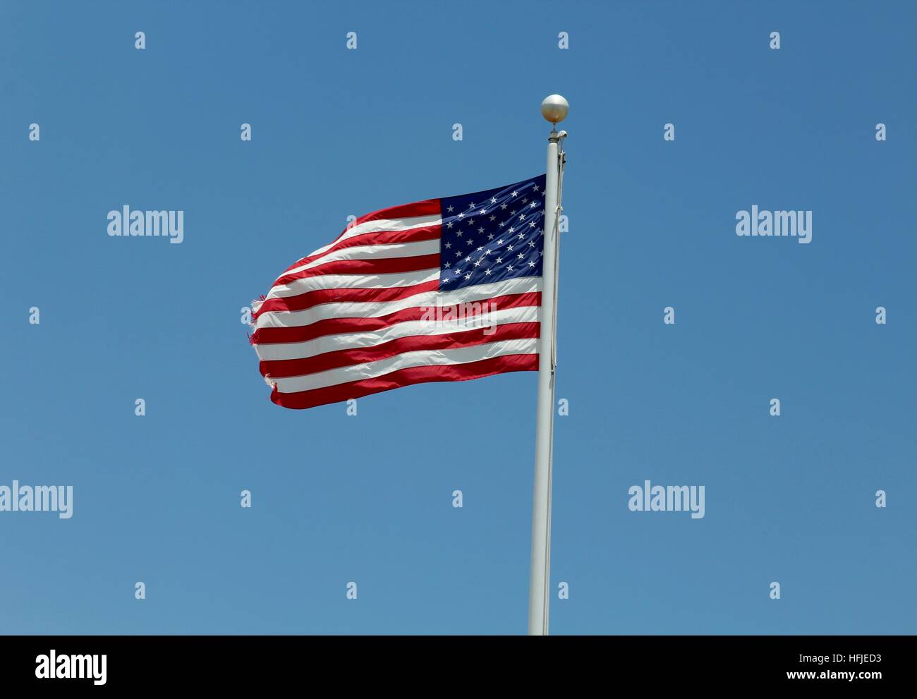The American flag against the blue sky background Stock Photo - Alamy