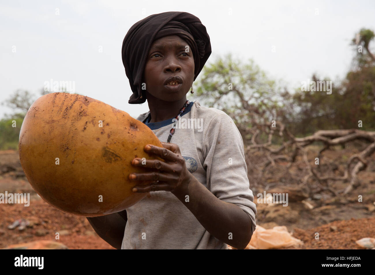 Sanana mine, Guinea, 2nd May 2015; Mariam Conde, mother of 6, collects ore rejected by miners to extract whatever small amounts of gold she can find. Stock Photo