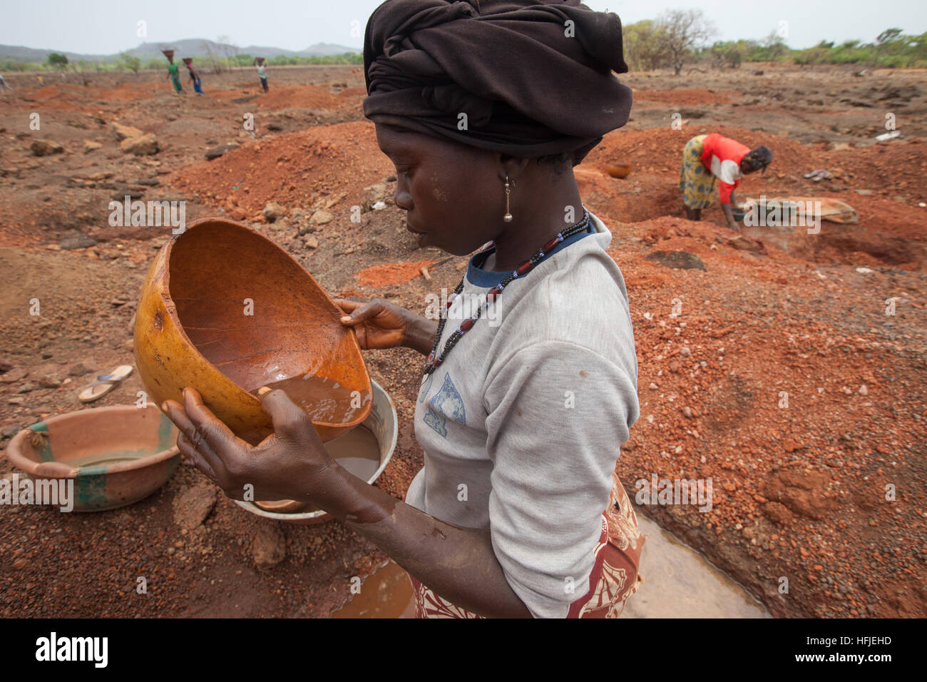 Sanana mine, Guinea, 2nd May 2015; Mariam Conde, mother of 6, collects ore rejected by miners to extract whatever small amounts of gold she can find. Stock Photo