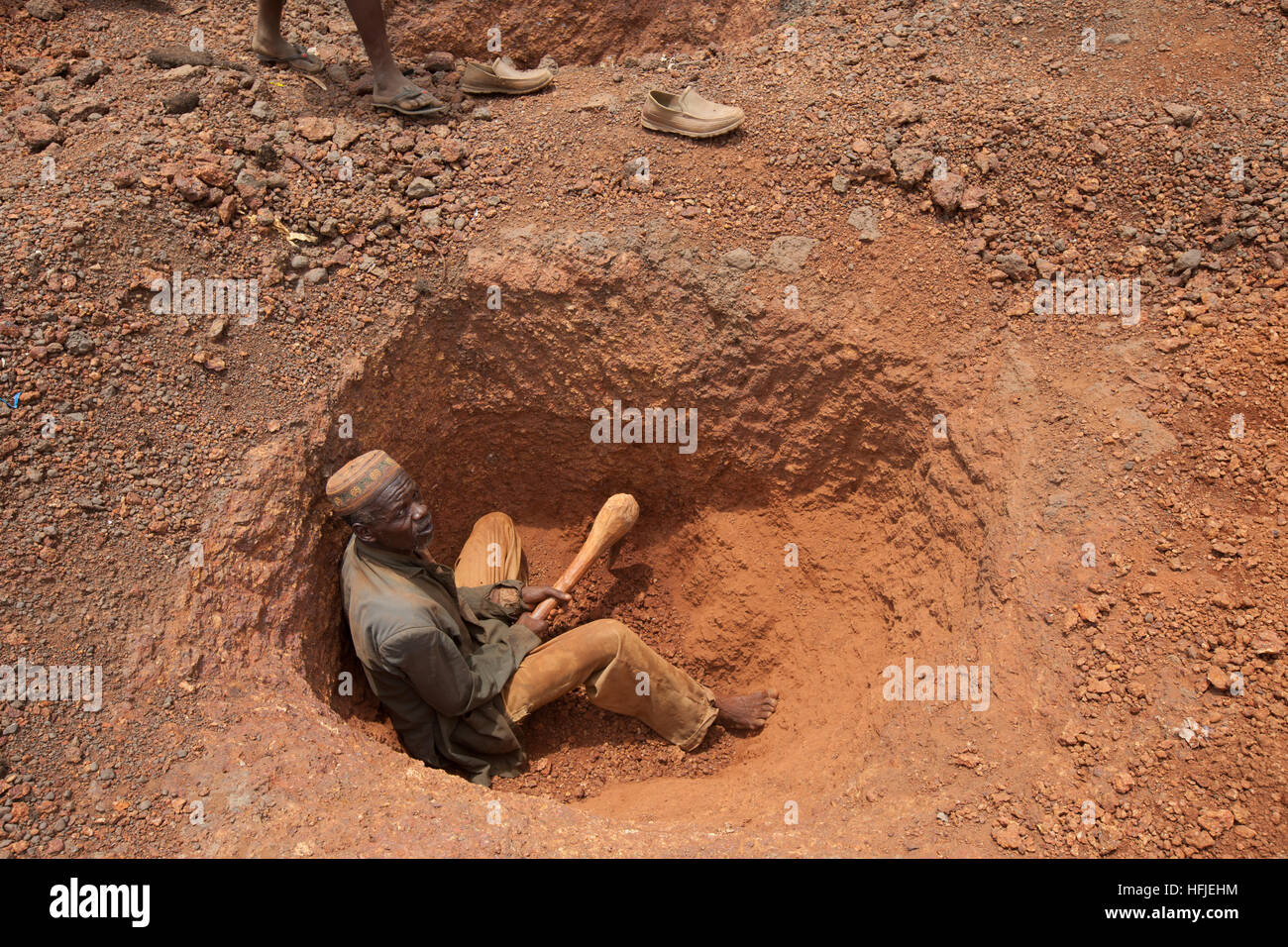 Sanana gold mine, Guinea, 2nd May 2015; An old miner digging a new plot in the dry-season  mid-day heat. Stock Photo