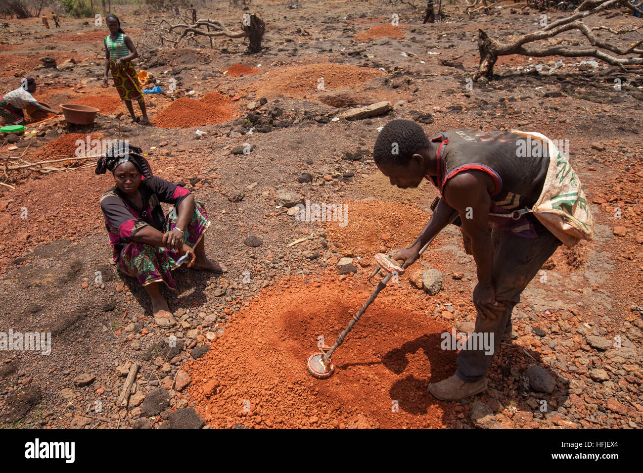 Sanana mine, Guinea, 2nd May 2015; Sanana mines, 12 km from Gbderedou Baranama  village, will be flooded by the Fomi dam.   Woman having low-grade ore checked.  She said the ore has already been checked three times by the miner who found nothing.  If she finds something now she will split it 2/3 to her and 1/3 to the checker. Stock Photo