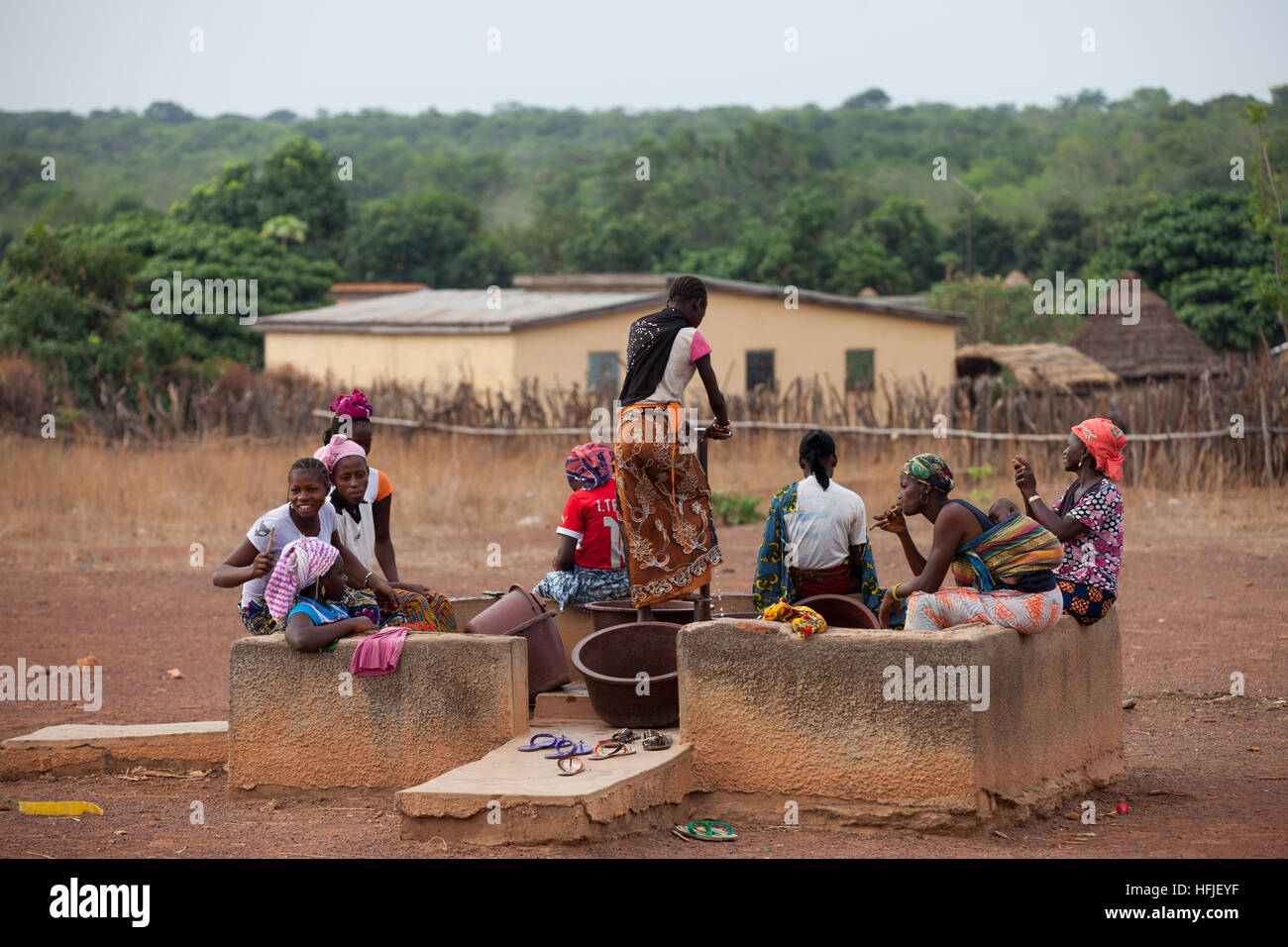 Koumban village, Guinea, 2nd May 2015; Women drawing water from a communal foot-pump water point. Stock Photo