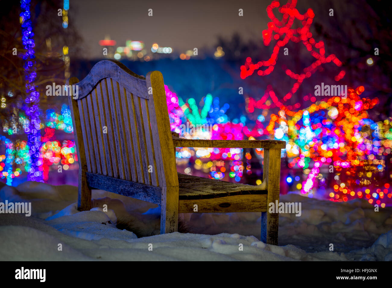 Christmas lights and a wood park bench in the winter snow Stock Photo ...