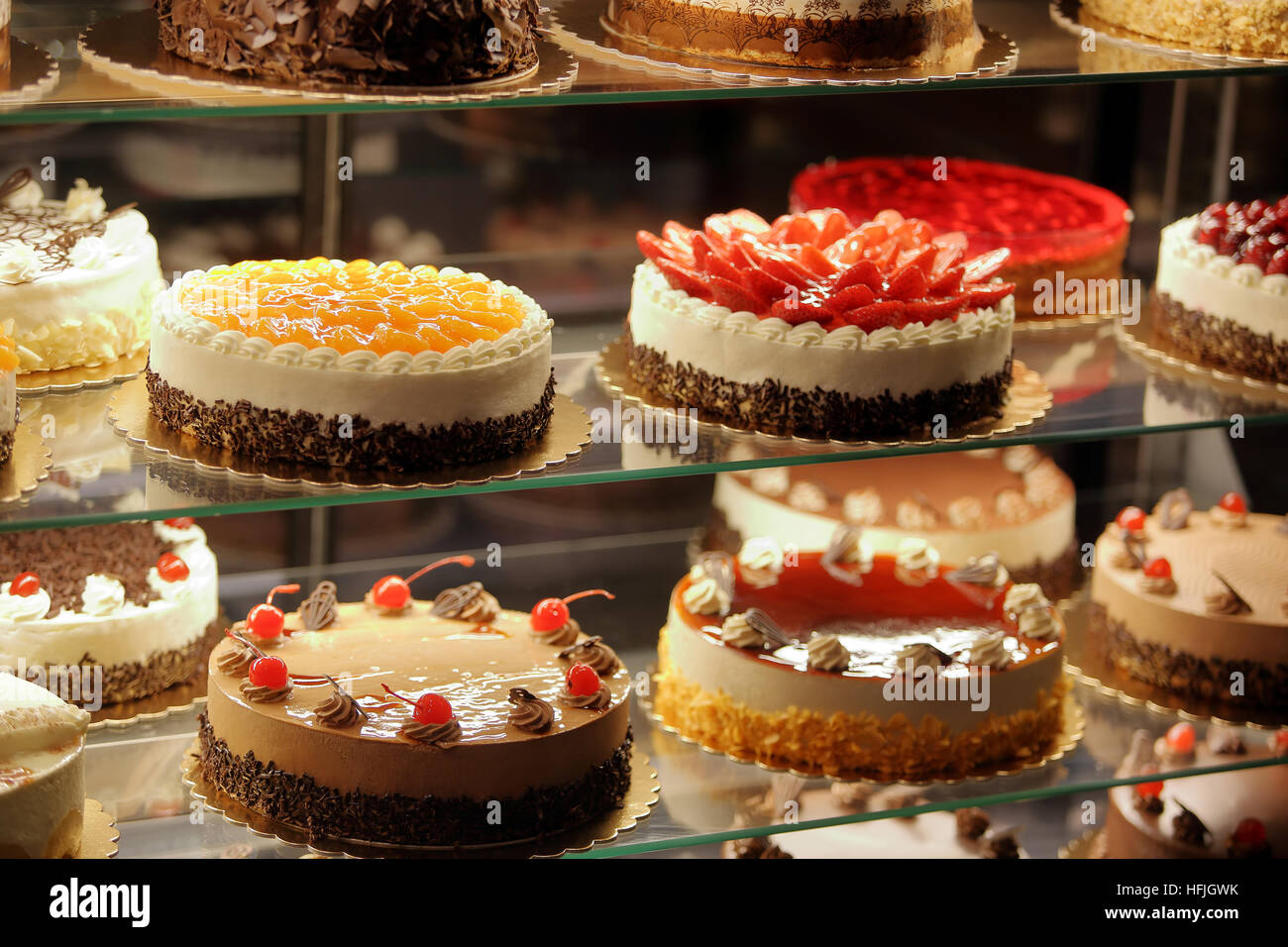 Different types of cakes in pastry shop glass display Stock Photo