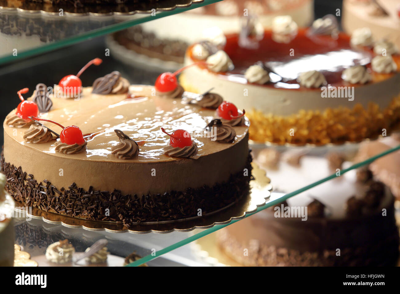 Different types of cakes in pastry shop glass display Stock Photo