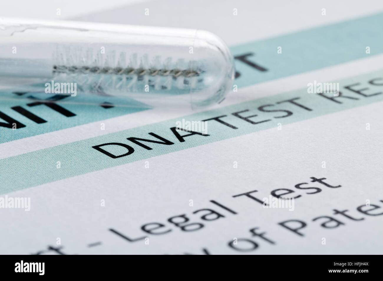 Buccal swab in test tube on paternity DNA test result chart form Stock