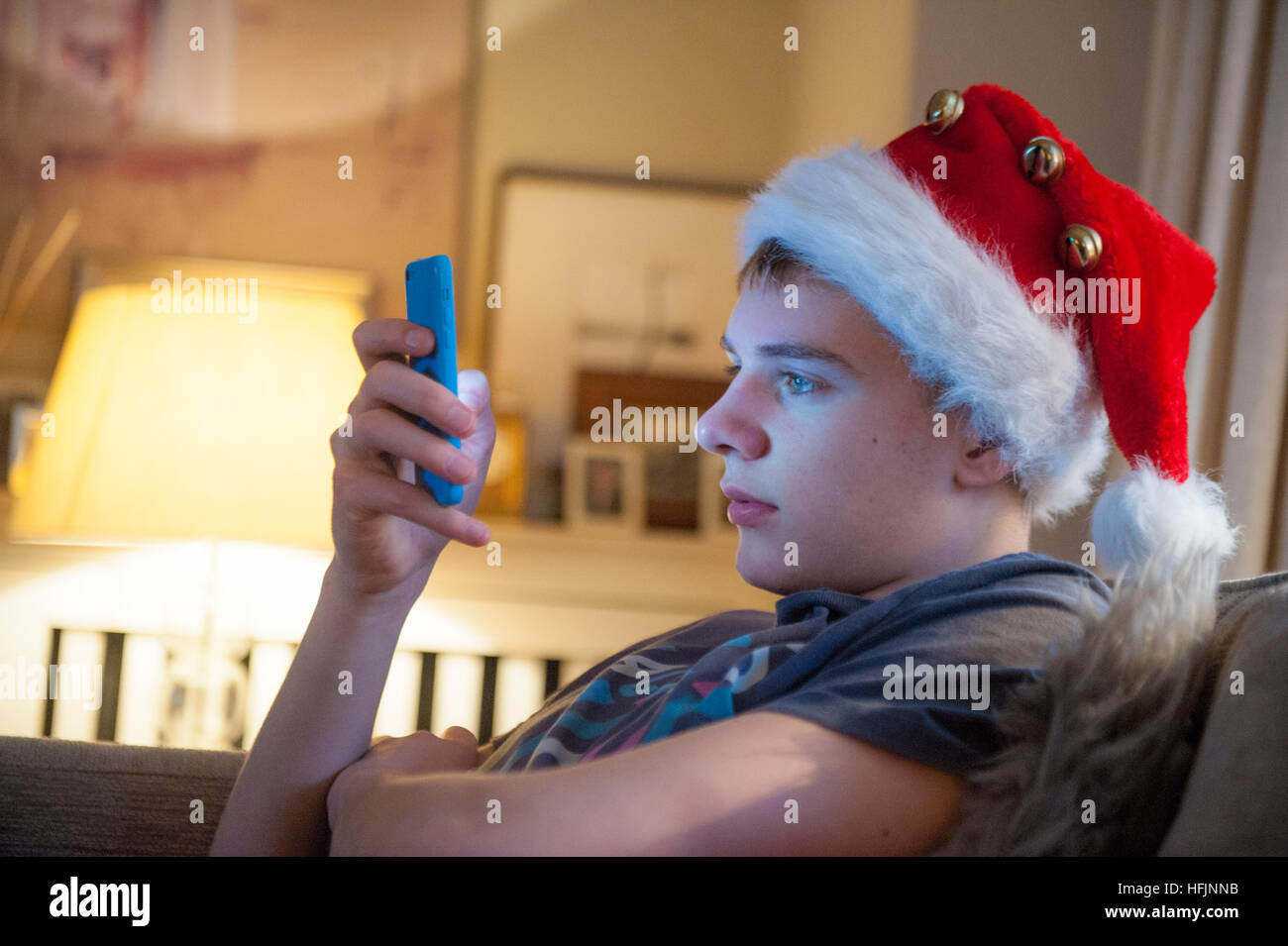 A teenage boy plays with his new phone at Christmas Stock Photo
