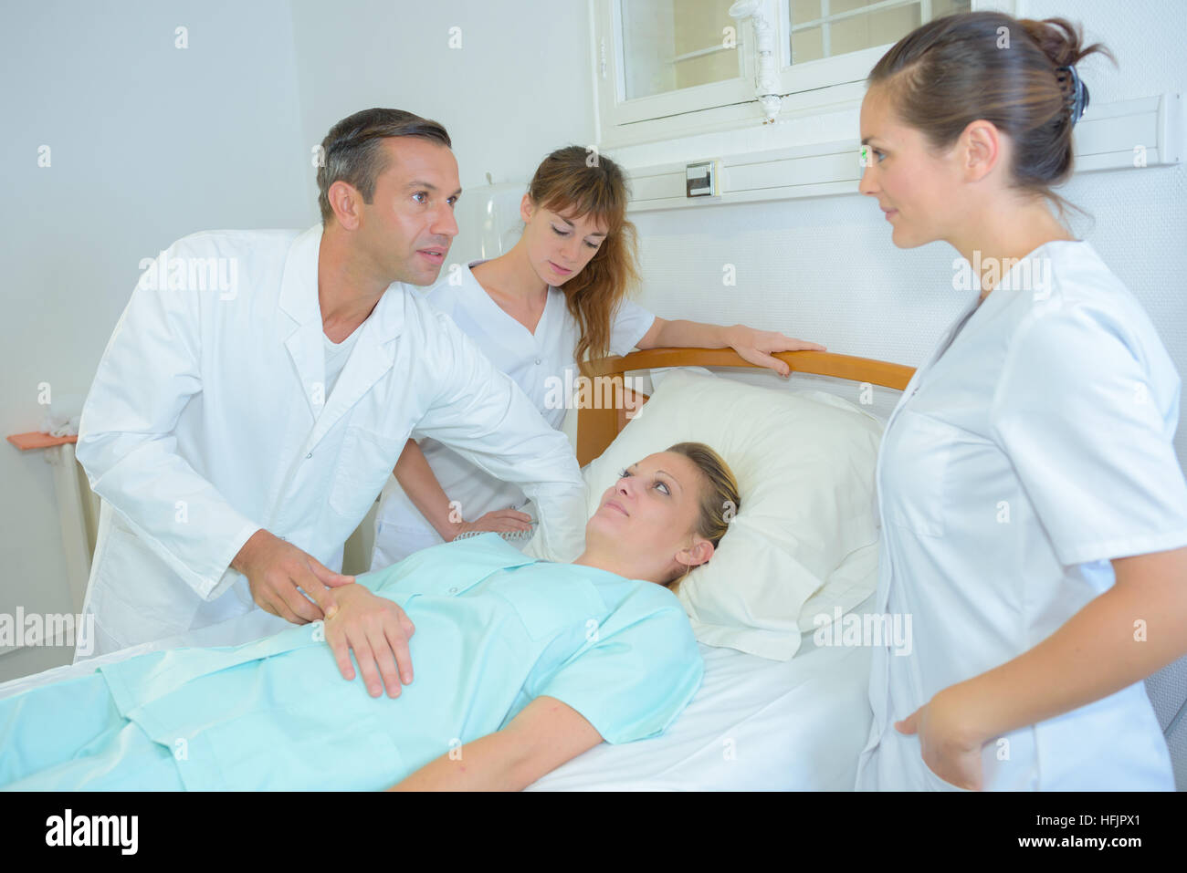 Doctor feeling pulse of patient Stock Photo