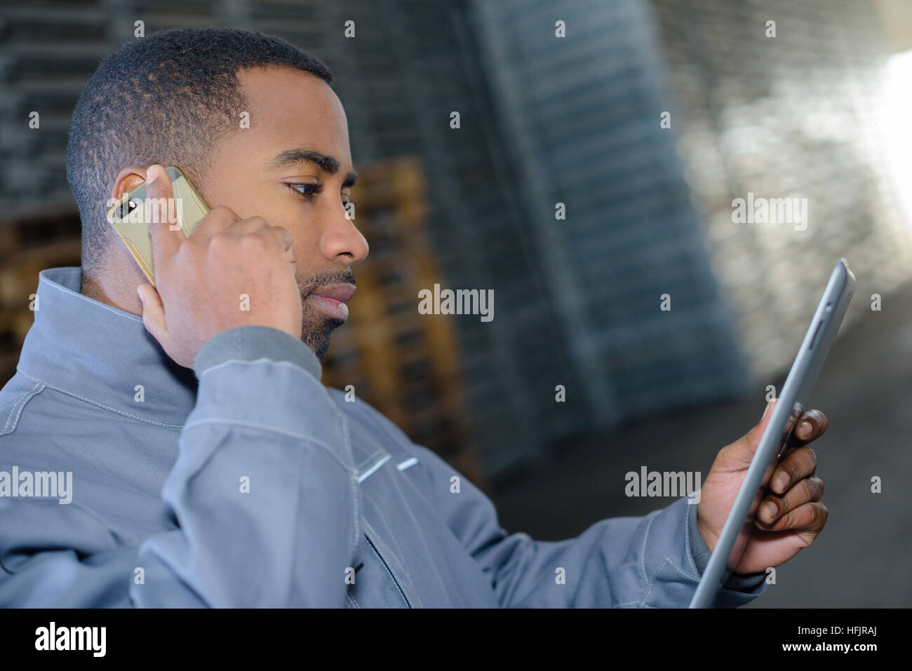 warehousing worker using tab and smartphone Stock Photo