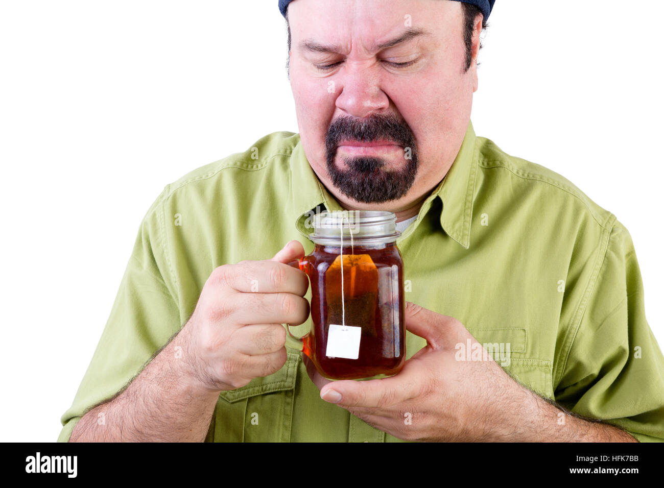 Uncertain middle aged man looking at herbal cup of tea on white Stock Photo
