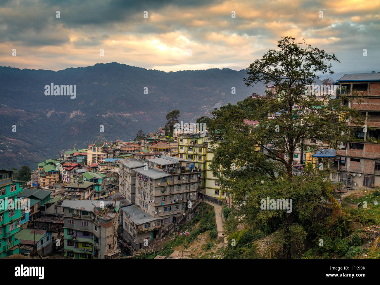 Sunset over Himalayan city of Gangtok, Sikkim, India with vibrant sky distant cliffs and buildings. Stock Photo