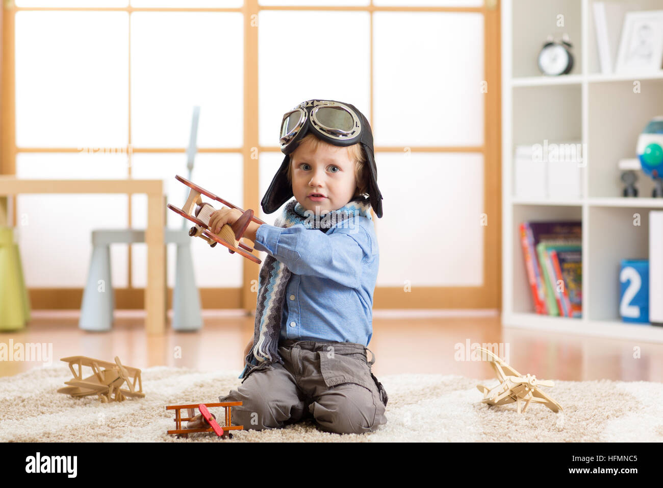 Cute baby dreaming of being pilot. Child boy playing with toy airplanes Stock Photo