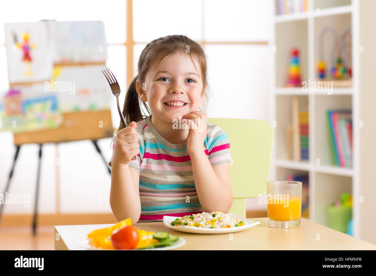 child little girl with fork ready to eat healthy food Stock Photo
