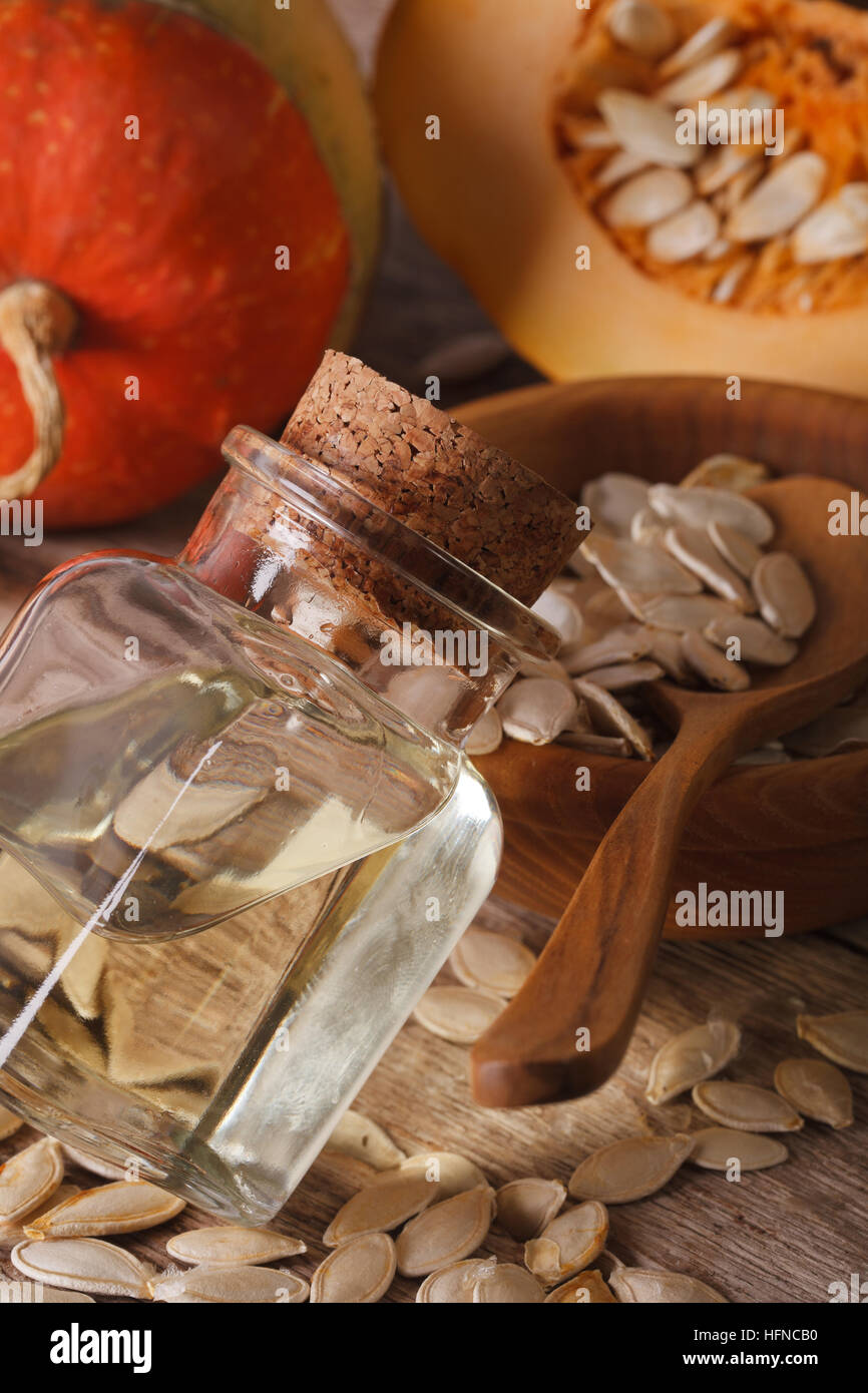 Helpful fresh pumpkin seed oil in a bottle macro on the table. vertical Stock Photo