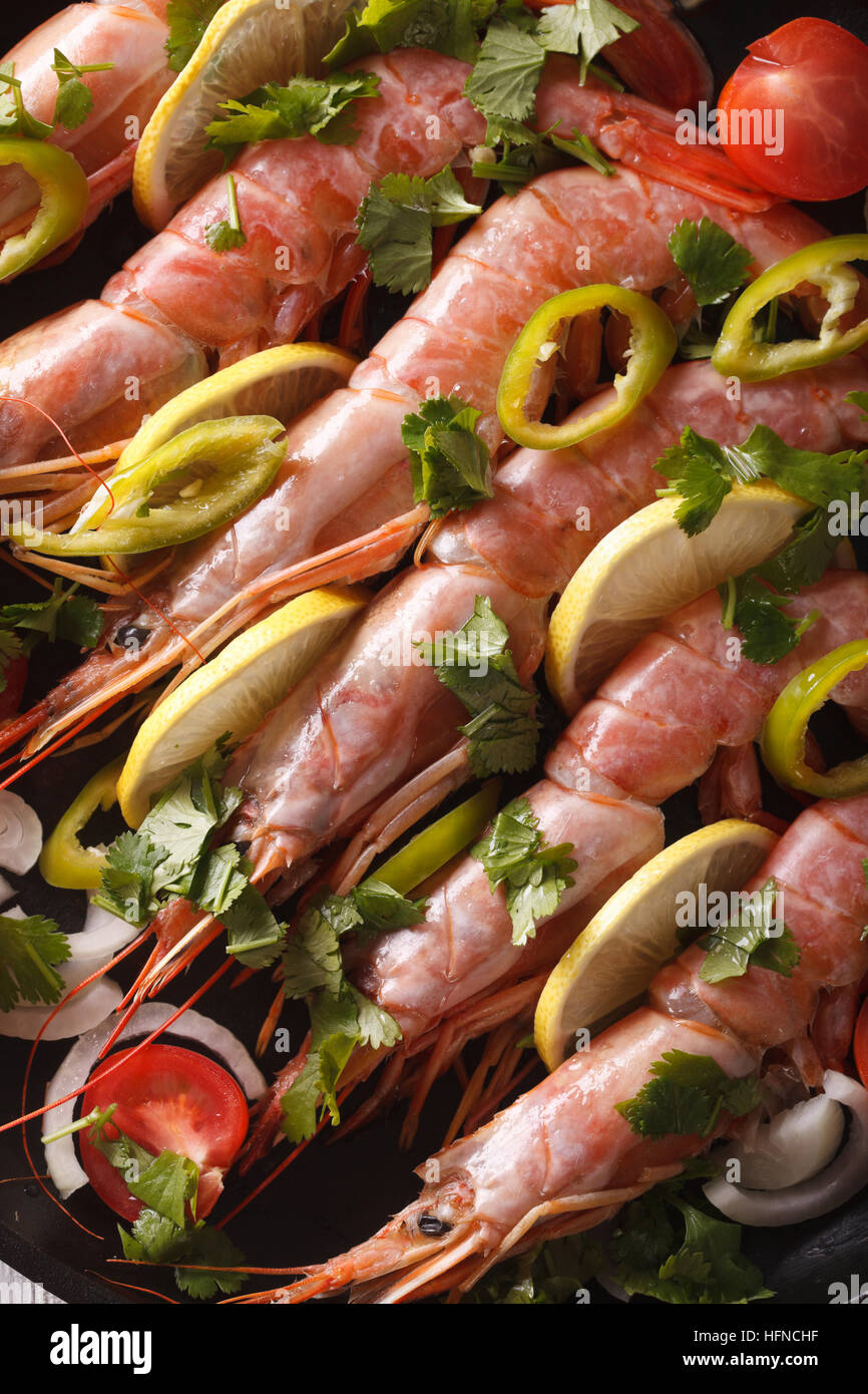 prawns with lemon and vegetables close-up. vertical top view background Stock Photo