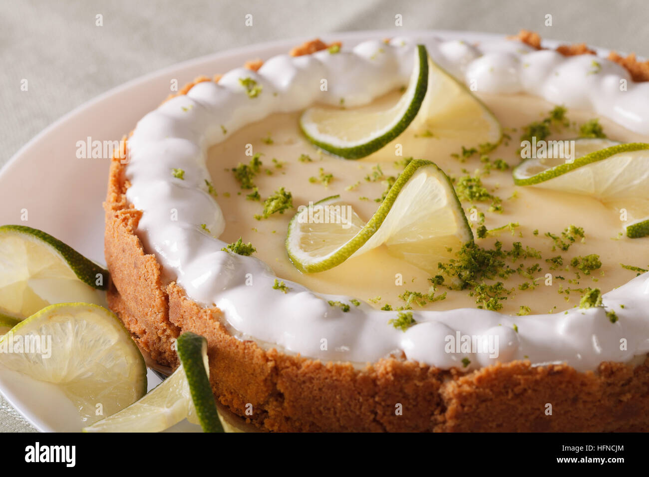 Beautiful key lime pie with whipped cream and peel closeup on a plate