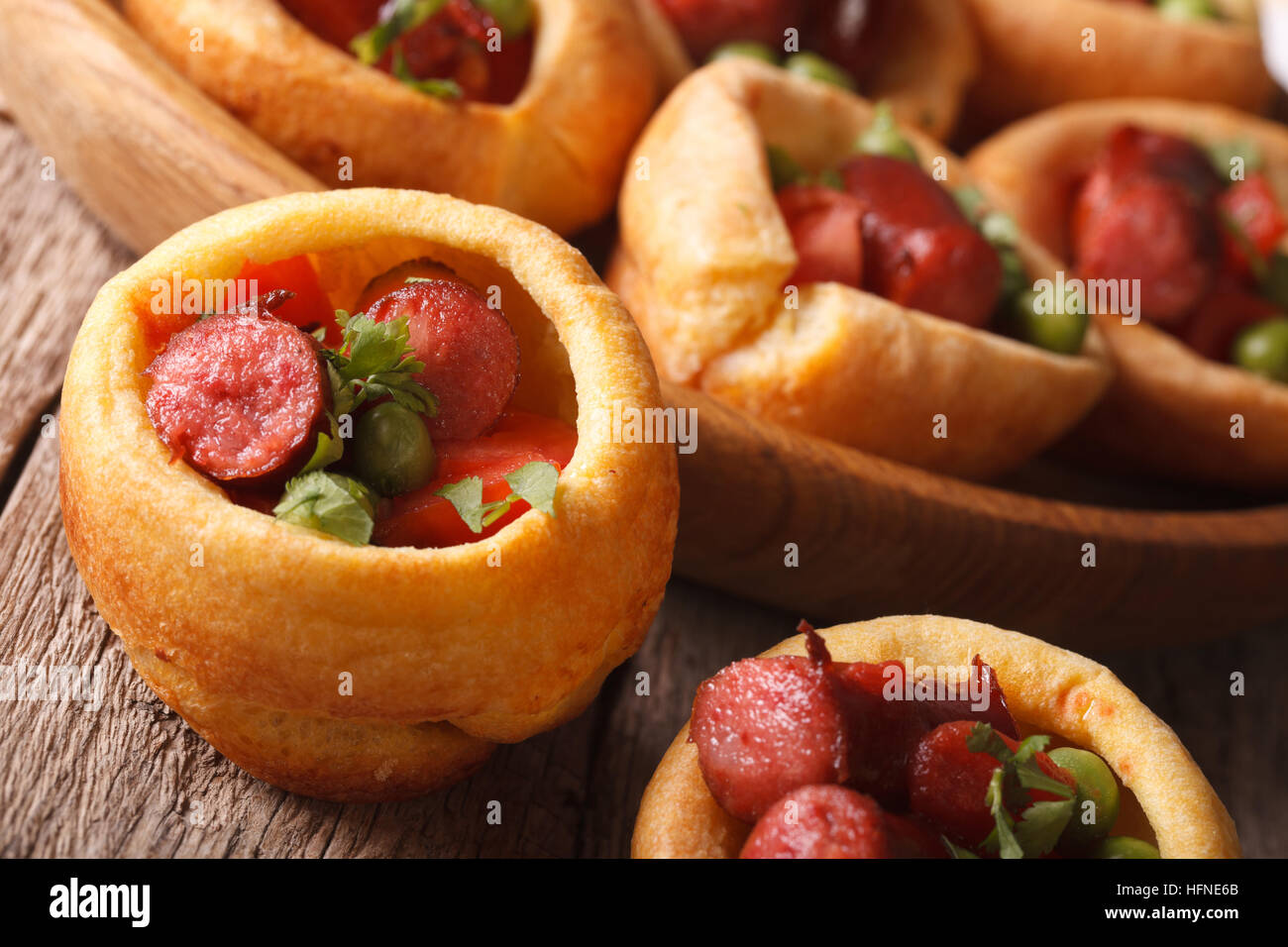 Yorkshire pudding filled with sausages and vegetables closeup on the