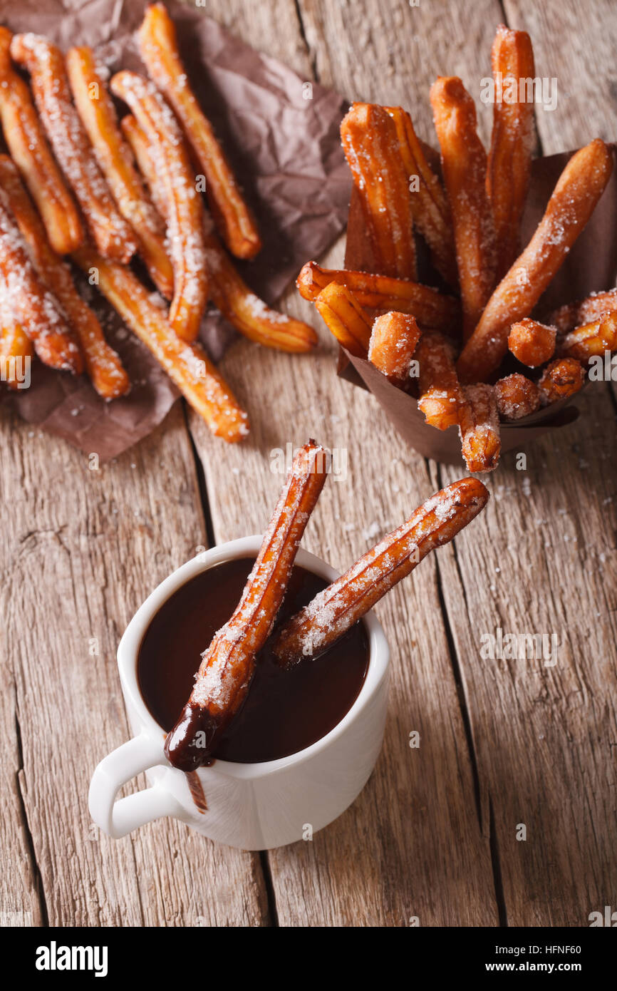 Spanish cookies churros dipped in chocolate in a cup. vertical top view Stock Photo