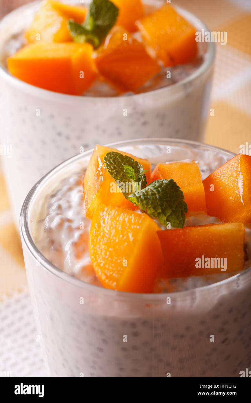 Chia seeds with yogurt and persimmon in a glass macro. Vertical Stock Photo