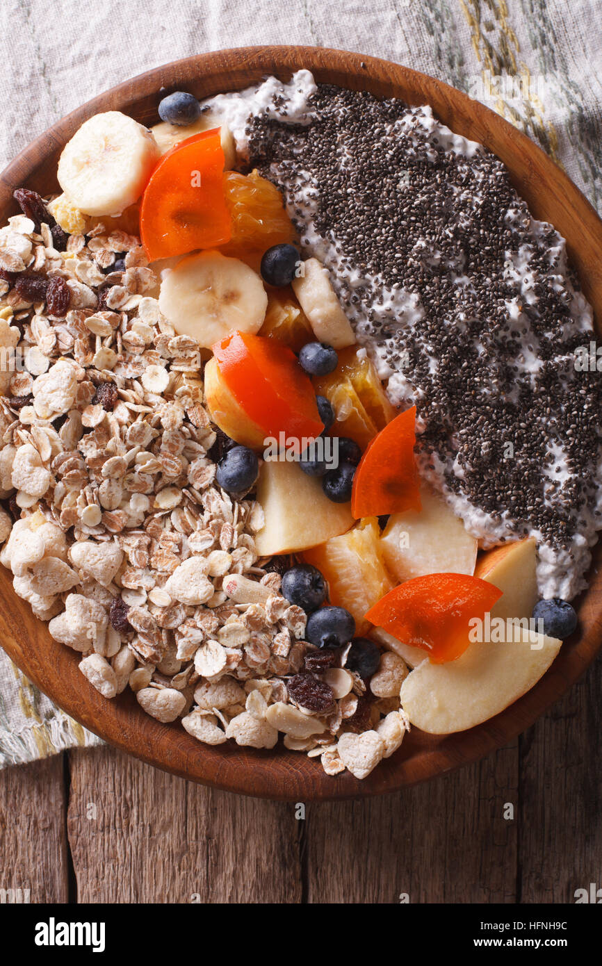 Healthy food: muesli with fruit and chia seeds close-up on a plate. vertical top view Stock Photo