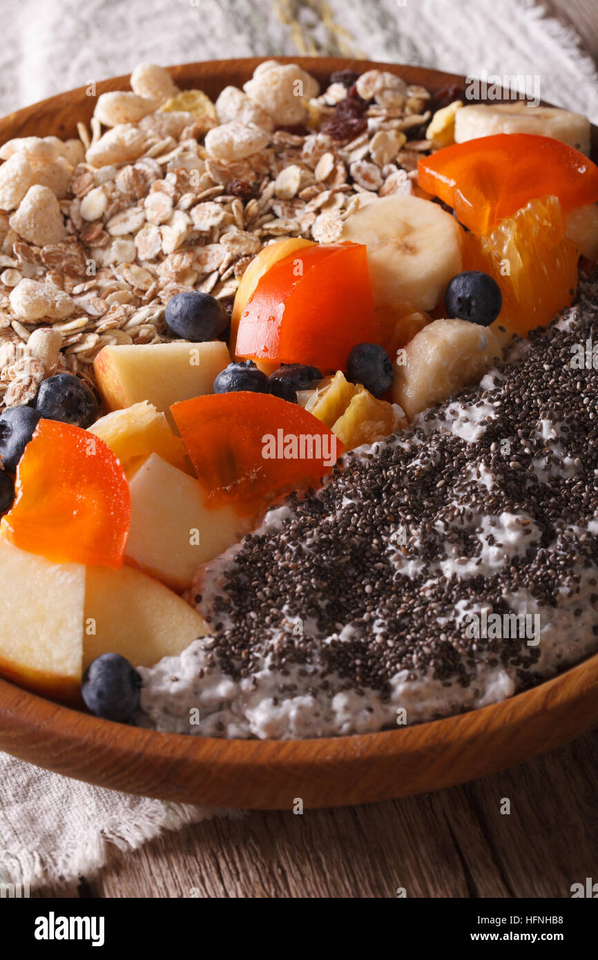 Healthy breakfast: oatmeal with fruit and chia seeds close-up on a plate. Vertical Stock Photo