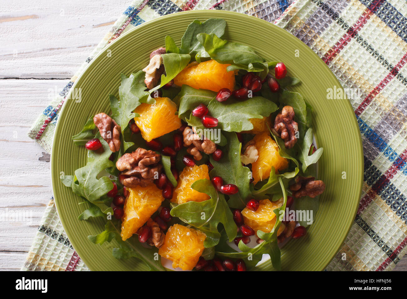 Healthy salad with orange, arugula and pomegranate close-up on a plate. horizontal top view Stock Photo