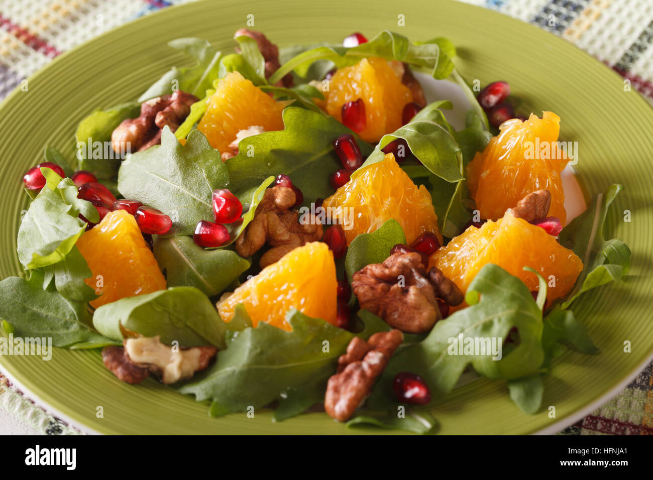 Fresh salad with pomegranate, orange and arugula close-up on a plate. horizontal Stock Photo