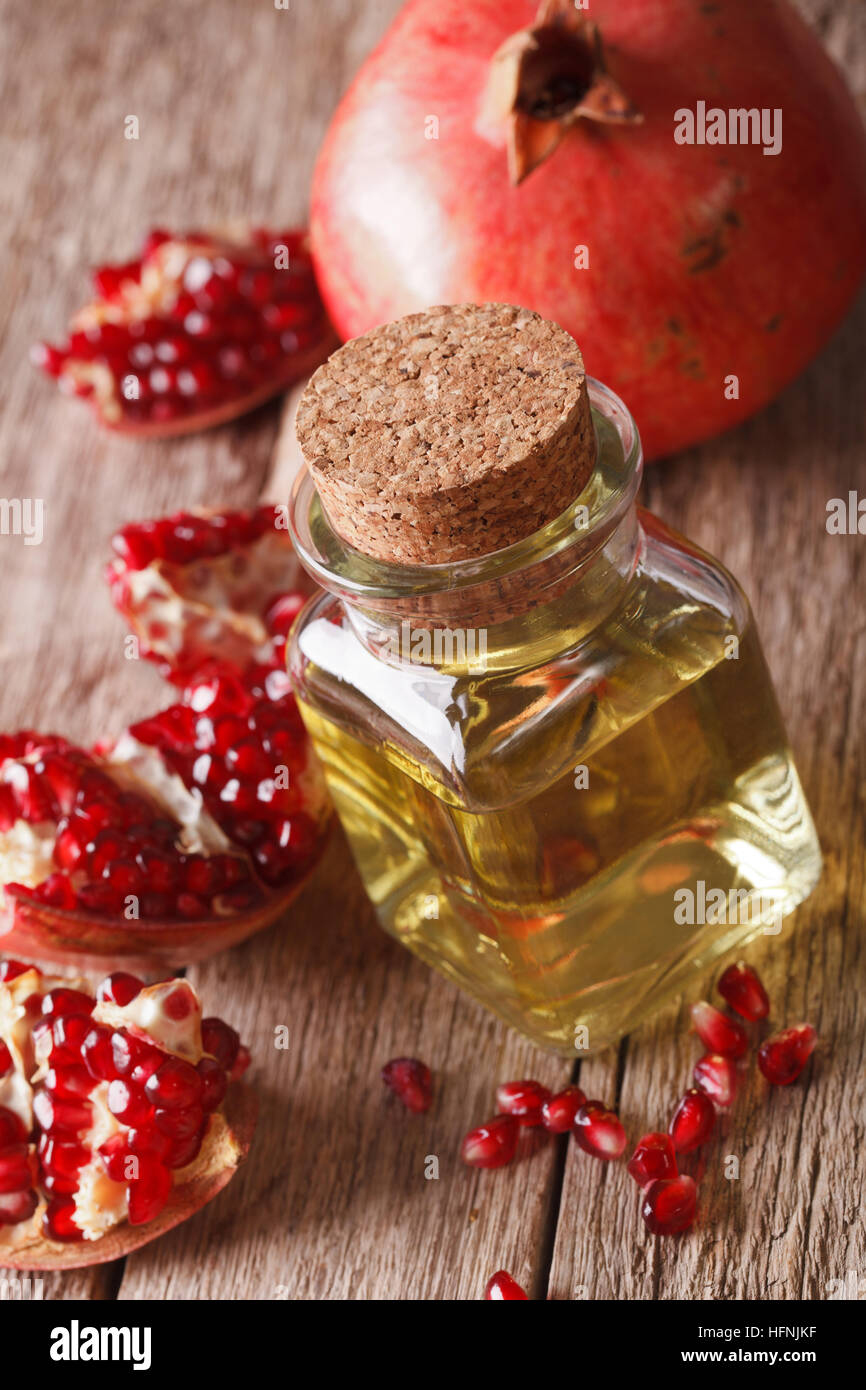 Fresh pomegranate seed oil in a glass bottle on a table macro. vertical Stock Photo