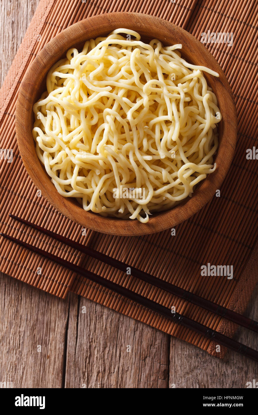 Asian ramen noodles in wooden bowl on the table. vertical top view Stock Photo