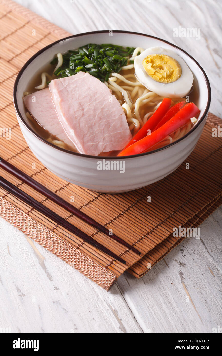 Ramen noodles in broth with pork, vegetables and egg in a bowl. vertical Stock Photo