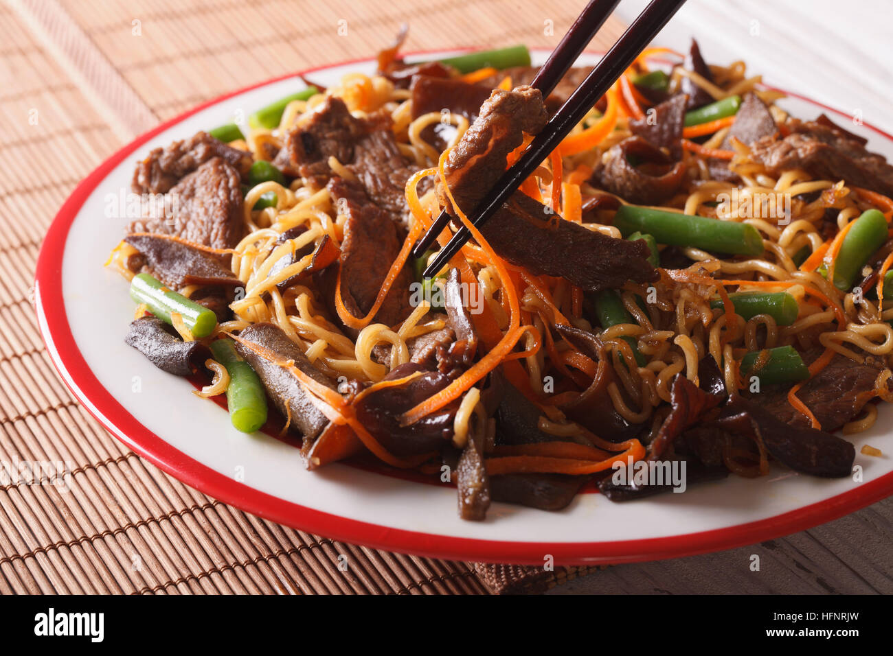 Lo mein Chinese noodles with beef and black fungus macro on a plate. Horizontal Stock Photo