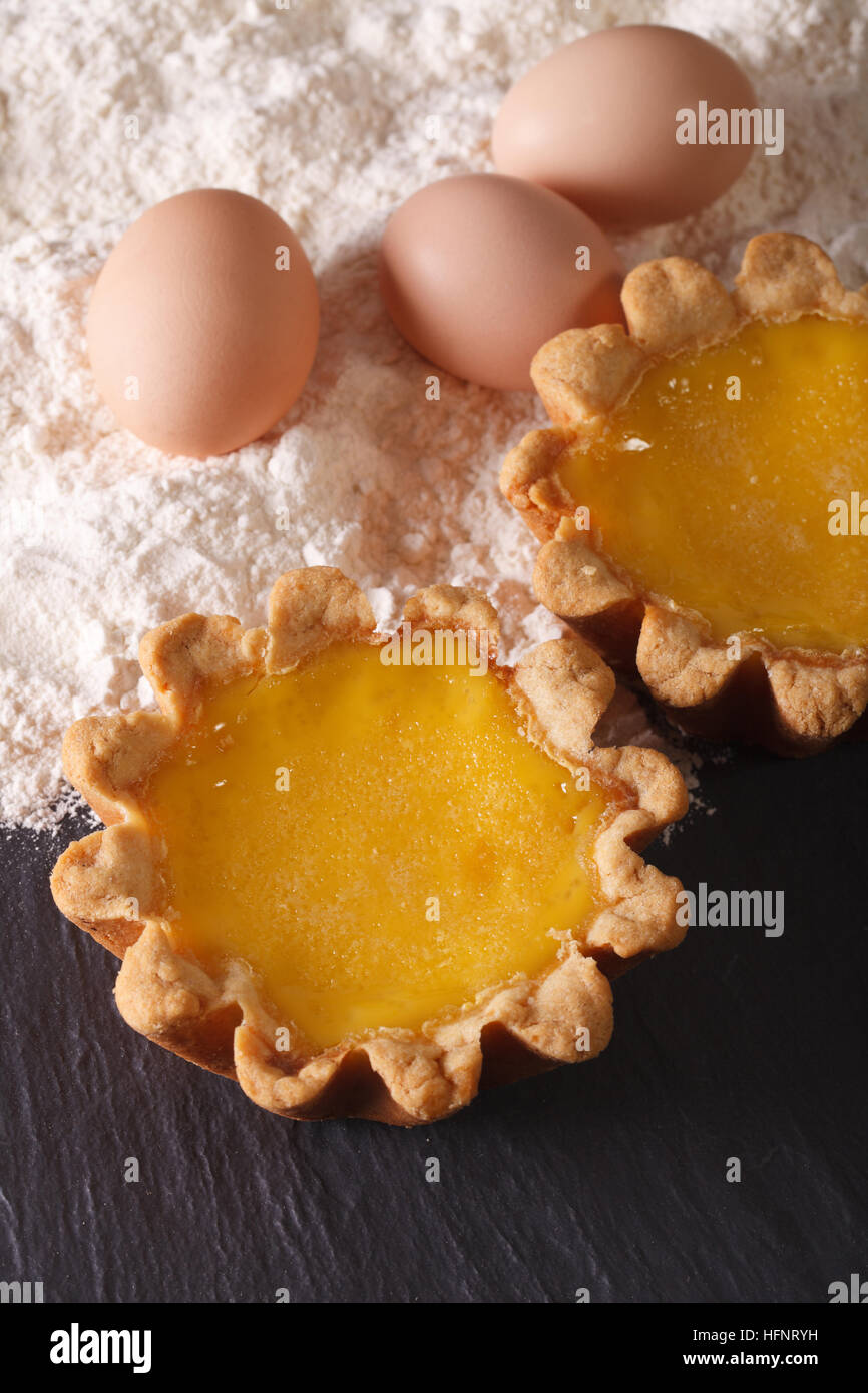 Traditional Egg Tart and ingredients on the table close-up. Vertical Stock Photo